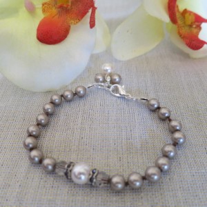 Eleganta rokasspradze ar Swarovski platīn-krāsas pērlēm un dekoratīvu elementu ar Swarovski krēmkrāsas pērlīti un Swarovski kristāliem, aizdare ar sudraba pārklājumu. Garums- 18-19 cm